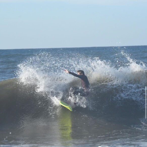 A person on a surfboard riding the waves.